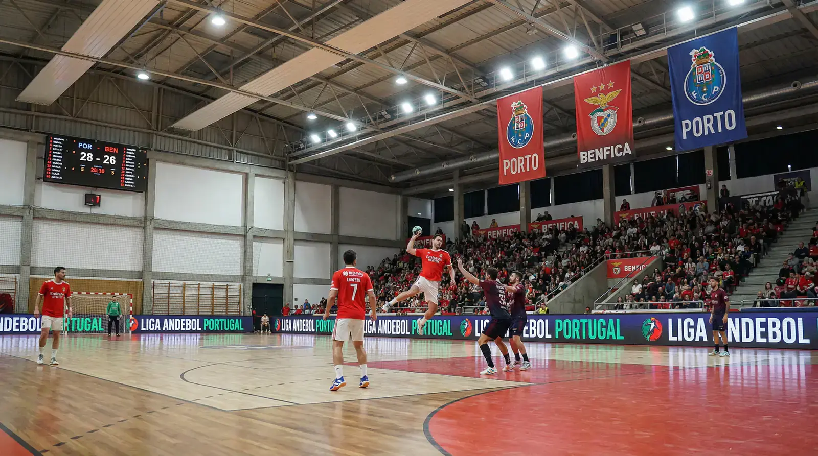 Jogadores de andebol do Benfica em ação com equipamento vermelho